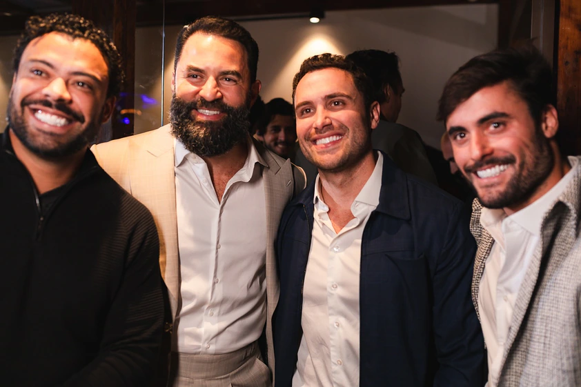 Convidados sorrindo juntos durante evento no The Roof 448