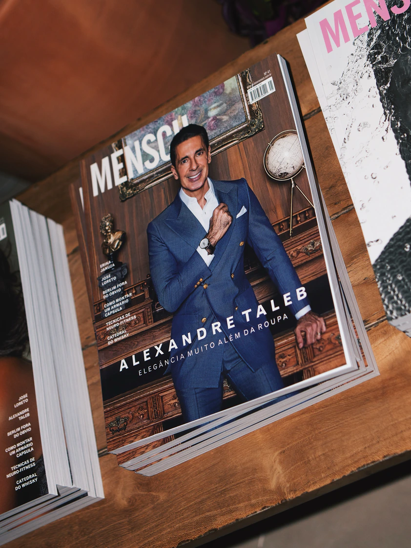 Revistas expostas sobre mesa de madeira em evento corporativo no The Roof 448