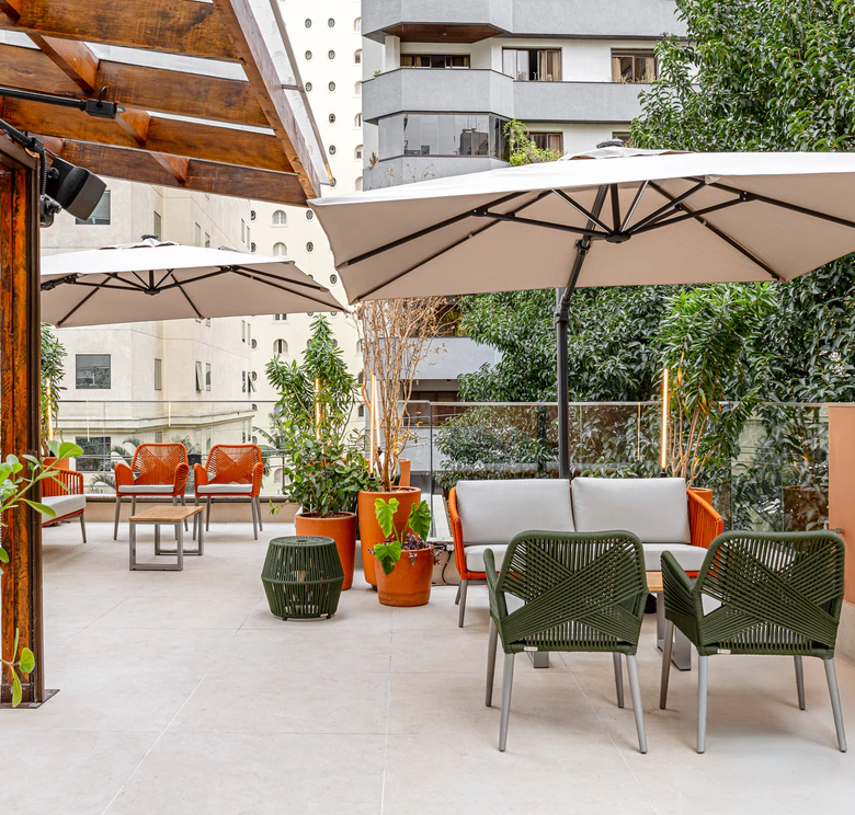Lounge externo do The Roof 448 com ombrelones e poltronas